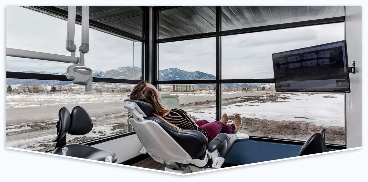 Woman seated in a dental chair inside a modern clinic, prepared for examination or treatment.
