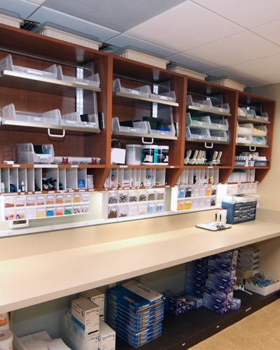 30-inch resupply sterilization cabinet with labeled drawers and upper storage compartments in a clinical workspace.